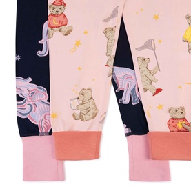 Close-up of children's pyjama bottoms in pink and navy with illustrated teddy bear print and pink ribbed cuffs