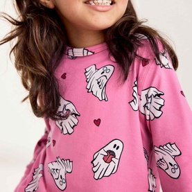 Model wearing Chelsea Peers bright pink ghost print nightwear top with long sleeves, hearts and ghost pattern detail, close-up crop shot.