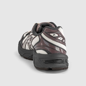 Asics trainer in oatmeal and obsidian grey, rear view showing chunky black rubber sole and silver logo detail.