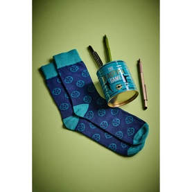 Gentlemen's Hardware Football Socks Tin, navy blue socks with teal trim and football motifs, shown with reusable gift tin and pencils on green
