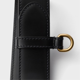 Prada Accessories black leather belt with contrast stitching and gold-tone D-ring hardware, close-up detail shot.