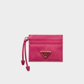 Prada card holder in fuchsia leather with gold triangle logo, zip detail, and rope pull tab