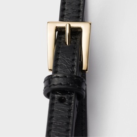 Prada Accessories black leather belt with gold-tone buckle, close-up detail shot showing stitched strap and keeper loop.