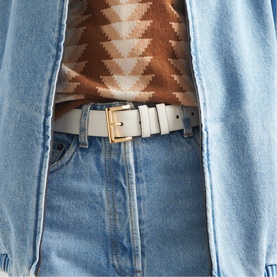 Prada Accessories white leather belt with gold-tone buckle, styled with light-wash jeans and a geometric print brown knit top