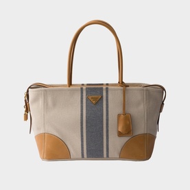 Prada Accessories neutral canvas tote bag with blue stripe detail, tan leather handles, corner panels, and gold-tone hardware
