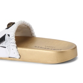 Kurt Geiger London white slide sandal with star embellishment, fluffy strap detail, and gold flatform sole, angled view