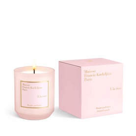 Maison Francis Kurkdjian &agrave; la rose candle in pink glass vessel with gold rim, shown lit beside matching pink gift box