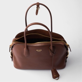 Prada Accessories brown leather tote bag with dual top handles, open top, beige interior, and gold-tone hardware with detachable strap.