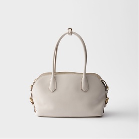 Cream leather structured tote bag with dual top handles, gold-tone hardware, and side buckle detail on a plain background