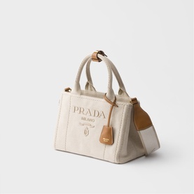Prada Accessories neutral canvas tote bag with printed logo, tan leather top handles, trim detail and removable tag.
