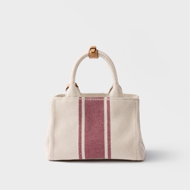 Cream canvas tote bag with burgundy stripe detail, short top handles, and gold-tone hardware
