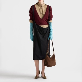 Model carrying Prada Accessories brown suede shoulder bag with wrap top, midi skirt and teal gloves