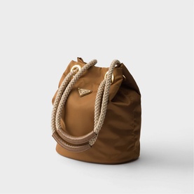 Prada Accessories brown nylon bucket bag with chunky rope handles and gold-tone triangular logo hardware.