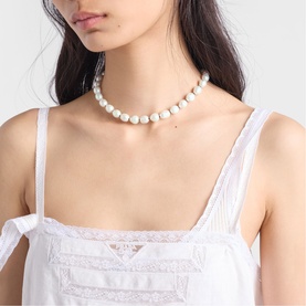 Model with white faux pearl beaded choker necklace, styled with a white lace-trim camisole top