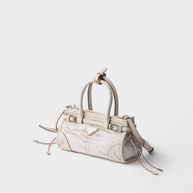 Prada Accessories white mini top-handle bag with silver-tone hardware, decorative side ties, and embossed pattern detail.