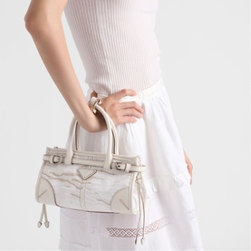 Model carrying Prada Accessories white leather handbag with silver-tone hardware, worn by hand, styled with white ribbed top and midi skirt