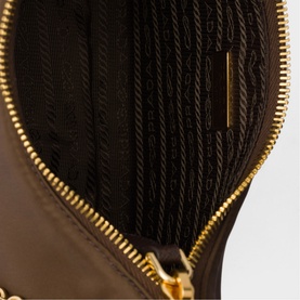 Interior view of dark brown bag showing black woven lining and gold-tone zip closure detail.