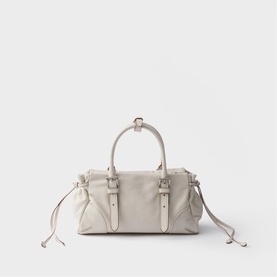 Cream leather mini barrel bag with silver-tone hardware, buckle straps, top handles, and removable crossbody strap