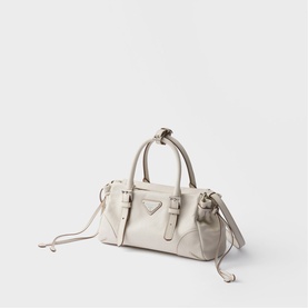 Prada ivory leather top-handle bag with triangle logo, buckle detail, knotted straps, and detachable shoulder strap, silver-tone hardware