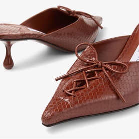 Jimmy Choo red snake-effect leather mules with pointed toe, lace-up bow detail, and slender kitten heel