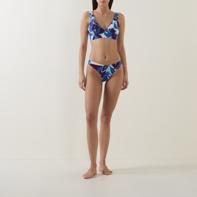 Model wearing Sea Level Bikini Bottom in Denim Blue floral print, paired with matching triangle bikini top.