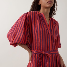 Model wearing Sea Level Vacay Boho Striped Shirt Dress in Spice Red with navy stripes, balloon sleeves and tie belt visible.