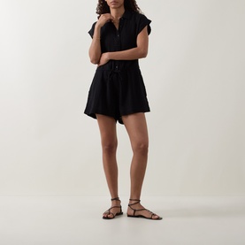 Model wearing Sea Level Sunset Textured Playsuit in black cheesecloth, shirt collar, front placket, elasticated waist, above-the-knee length, with