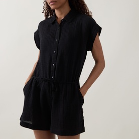 Model wearing Sea Level Sunset Textured Playsuit in black cheesecloth, shirt collar, dropped shoulders, elasticated waist, above-the-knee length