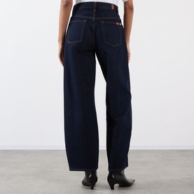 Model wearing dark indigo wide-leg jeans, rear view, styled with black ankle boots