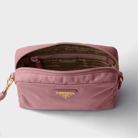 Prada pink nylon pouch bag with gold-tone triangle logo, open top showing patterned interior lining and zip compartment