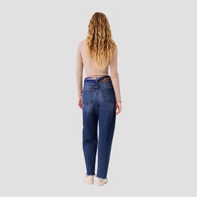 Model wearing Maje clear wash jeans, back view, styled with a pale pink long-sleeve top and white trainers.