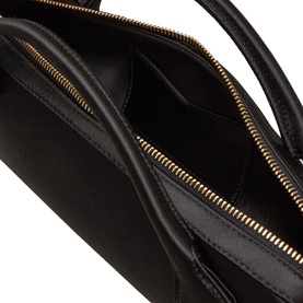 Ala&iuml;a noir calf leather clutch, open top view showing interior compartments with gold-tone zip detail