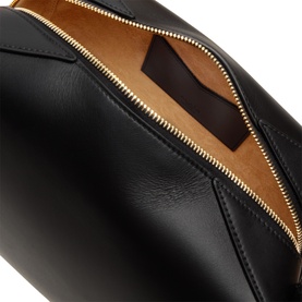 Alaia noir calf leather shoulder bag, open showing tan interior lining with gold-tone zip fastening