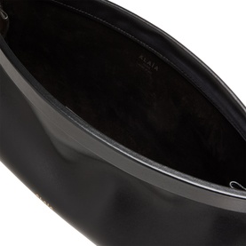 Alaia Le Click Medium Shoulder Bag in Noir, interior view showing smooth black leather lining and gold-tone brand lettering.