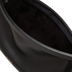 Alaia Le Click Small Shoulder Bag in noir smooth leather, open view showing dark interior lining and gold-tone rim detail.