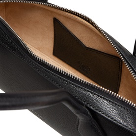Alaia noir leather shoulder bag open interior view, showing tan suede lining, zip pocket and gold-tone zipper detail.