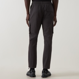 Model wearing Arne Utility Cargo Casual Trousers in grey, showing rear view with 3D cargo pockets and bungee cord hems