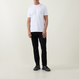 Model wearing Arne Essential Solid T-Shirt in white, crew neck, short sleeves, styled with black slim-fit trousers and black trainers.