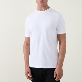 Model wearing Arne Essential Solid T-Shirt in white; crew neck, short sleeves, straight hem, paired with black trousers.