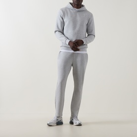 Model wearing Arne Essential Solid Hoodie in Marl Grey with matching joggers and grey trainers.