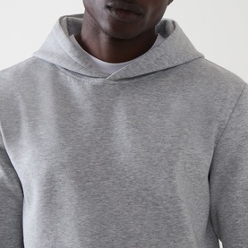 Model wearing Arne Essential Solid Hoodie in Marl Grey, close-up showing fixed three-panel hood and mid-weight jersey fabric