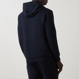 Model wearing Arne navy hoodie, back view, styled with matching navy joggers.
