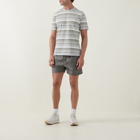 Model wearing Arne sage swim shorts with white stripe T-shirt and white trainers
