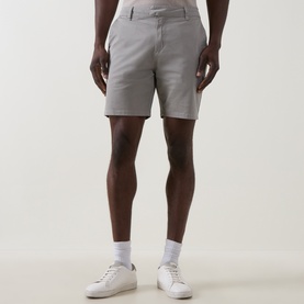Model wearing Arne stone cotton shorts with white trainers and white socks