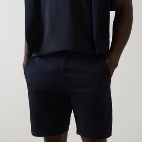 Model wearing Arne Tailored Slim-Leg Chino Shorts in navy, mid-rise slim fit, styled with a dark navy T-shirt
