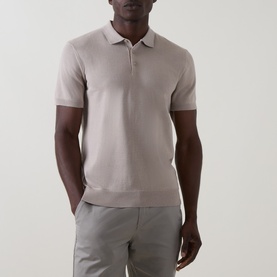 Model wearing Arne Stone knit polo shirt, styled with light grey trousers. Short sleeves, open collar with zip placket.