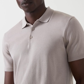 Model wearing Arne Stone knit polo shirt, close-up showing ribbed collar and three-button placket detail