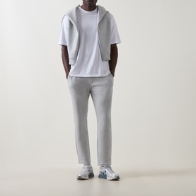 Model wearing Arne Essential Slim-Leg Sweatpants in Marl Grey, styled with a white tee, grey zip hoodie and white trainers.
