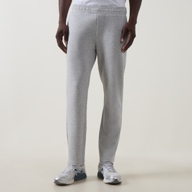 Model wearing Arne Essential Slim-Leg Sweatpants in Marl Grey, tapered fit with elasticated waistband, styled with white trainers.