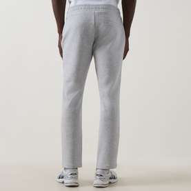 Model wearing Arne Essential Slim-Leg Sweatpants in Marl Grey, shown from behind, styled with white trainers.